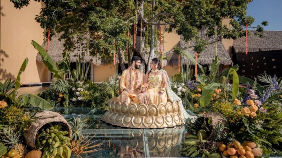 A man and woman sitting on a circular object in a garden