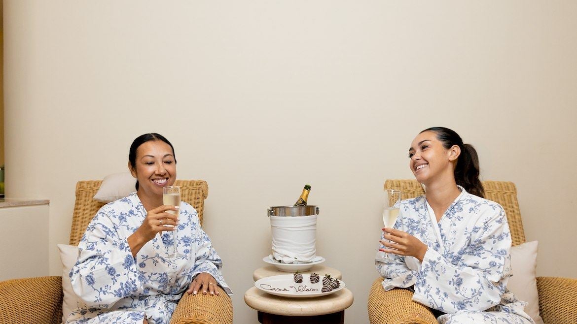dos mujeres en bata sentadas tomando té